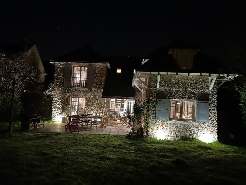 The house lit up at night from the garden
