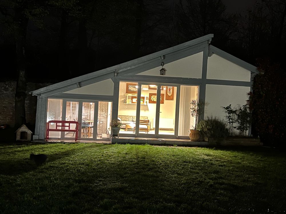 The guest cottage lit up at night